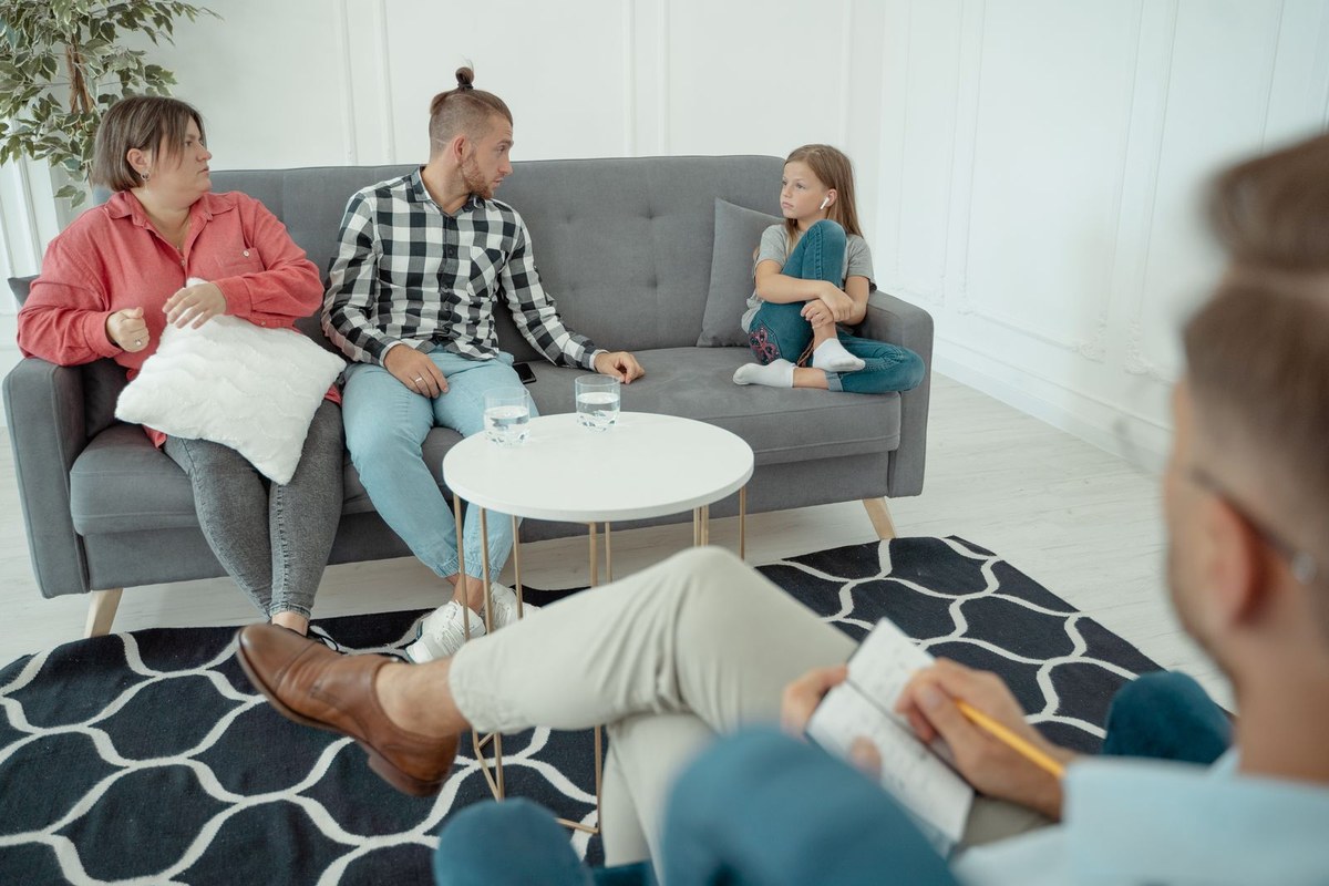 Parents et enfant échangeant avec une thérapeute en consultation familiale