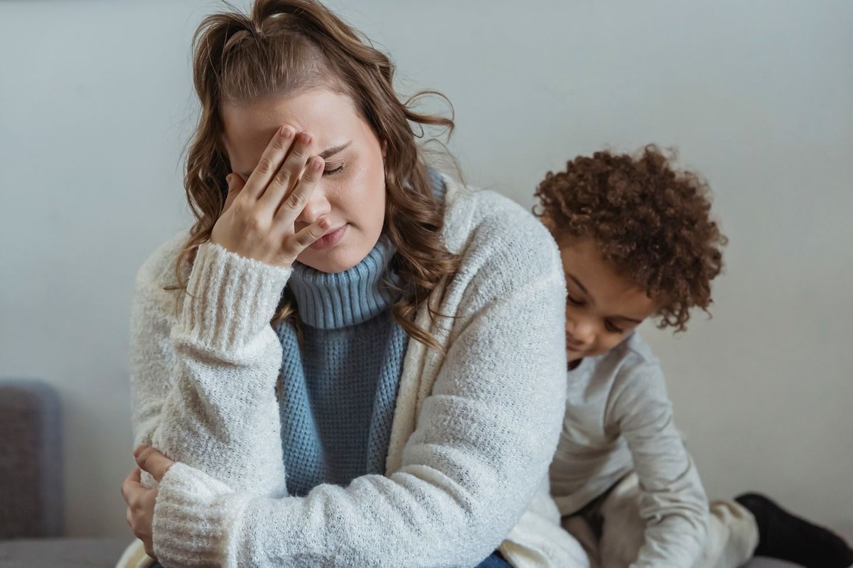 Parent seul fatigué assis auprès de son enfant à la maison