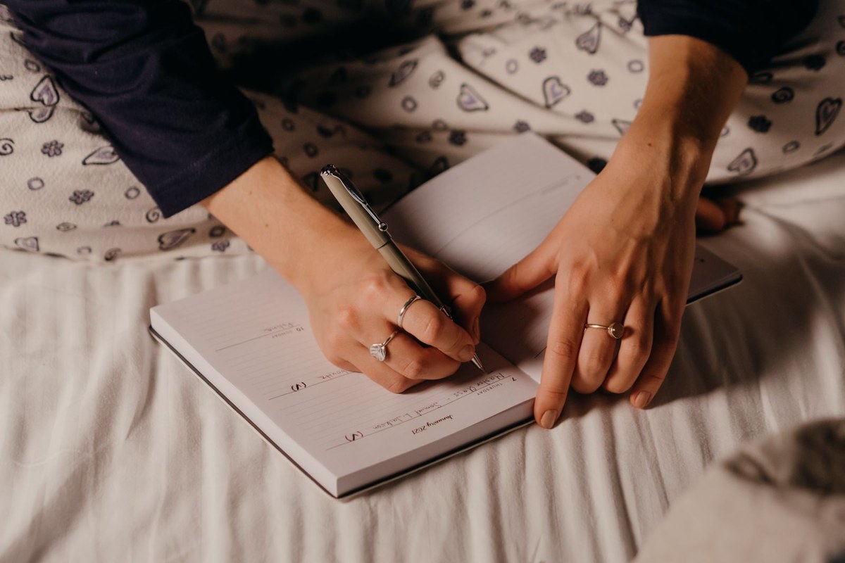 Main écrivant dans un journal lors d'un moment de réflexion