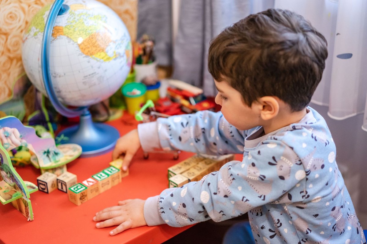 Enfant jouant avec des lettres et développant de nouvelles compétences