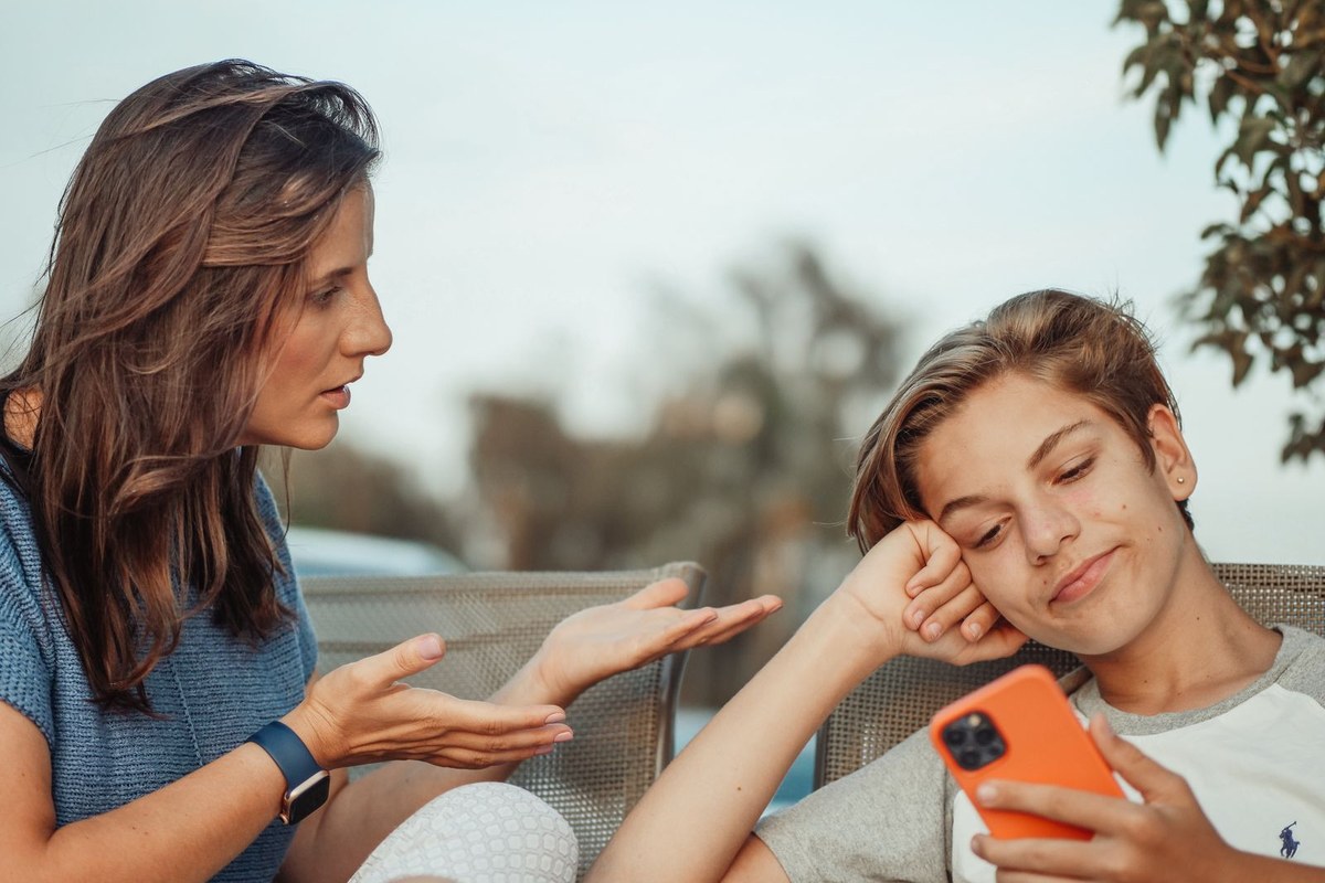 Parent discutant avec un adolescent au sujet de son téléphone