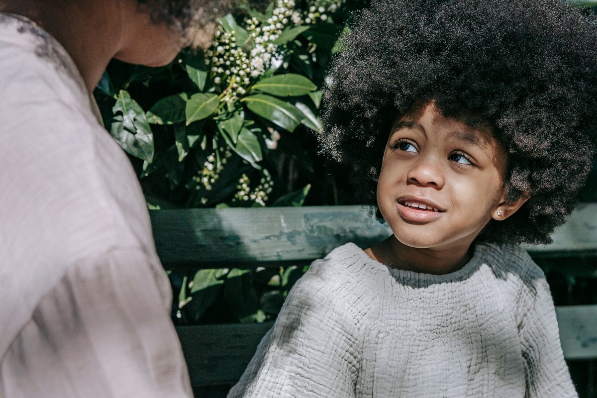 Parent et enfant discutant calmement sur un banc