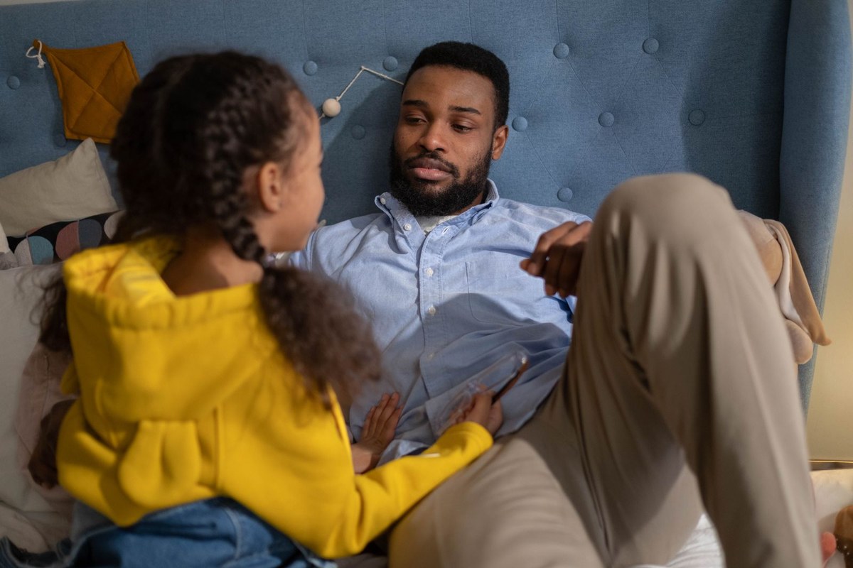 Père échangeant calmement avec son enfant à la maison