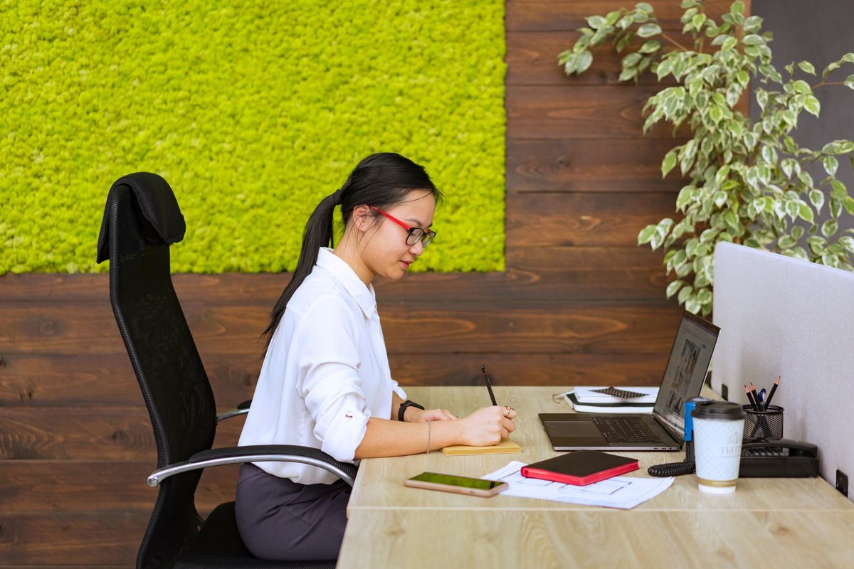 Professionnelle concentrée prenant des notes à son bureau