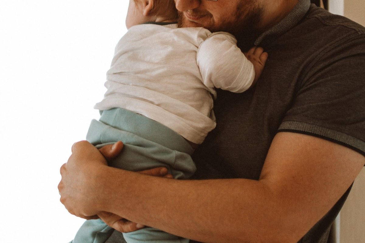 Père rassurant son enfant dans ses bras