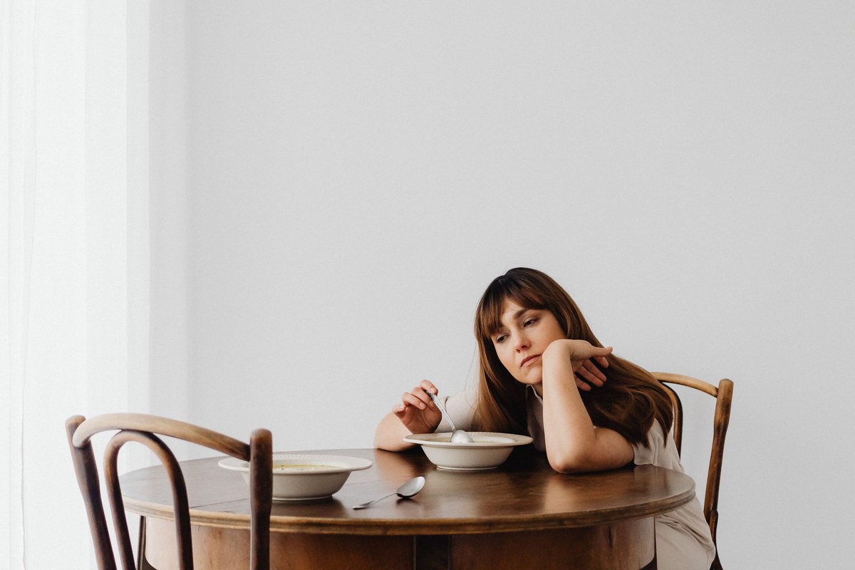 Personne seule à table dans un moment d'attente et d'inquiétude relationnelle