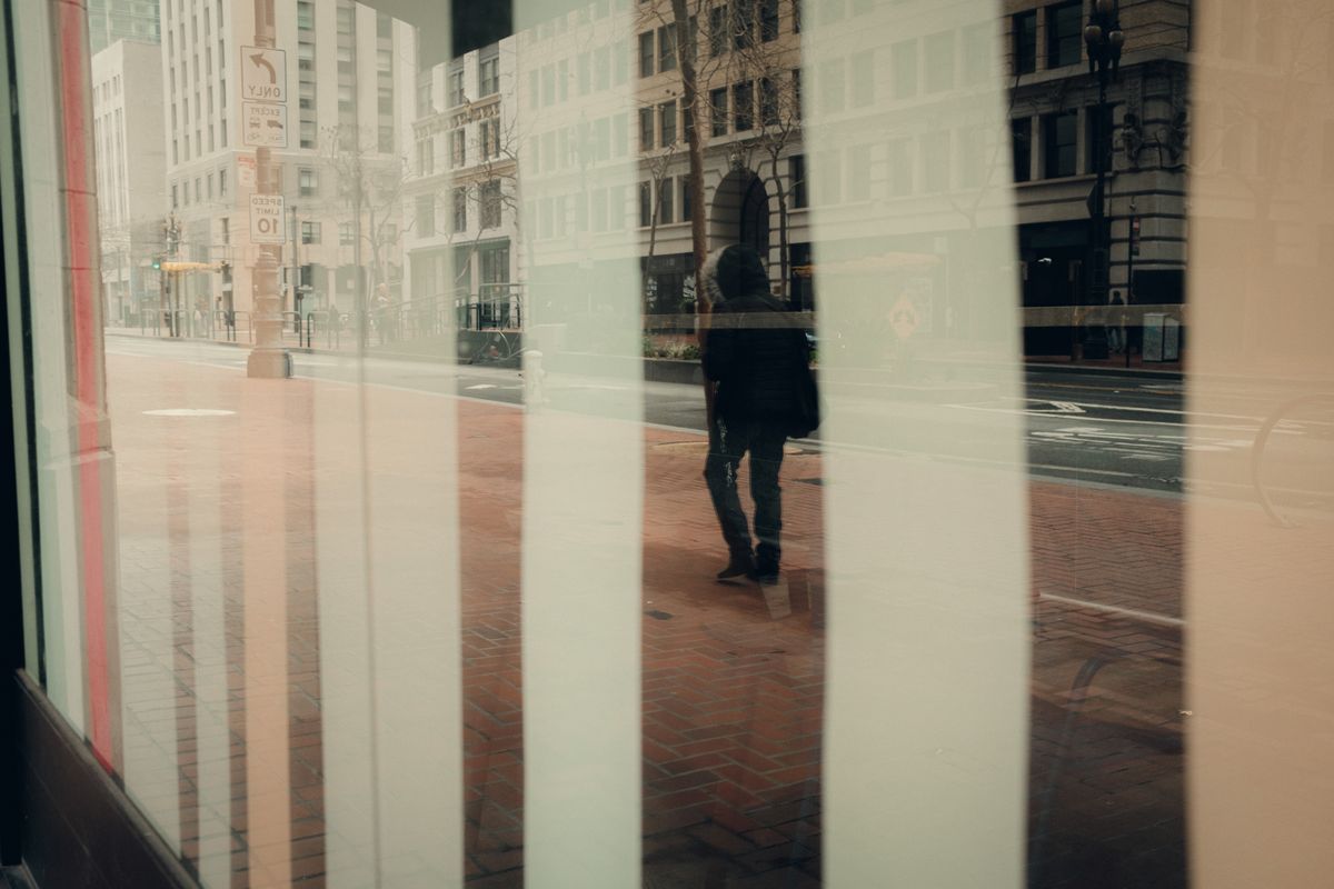 Reflet d'une personne dans une vitrine en ville
