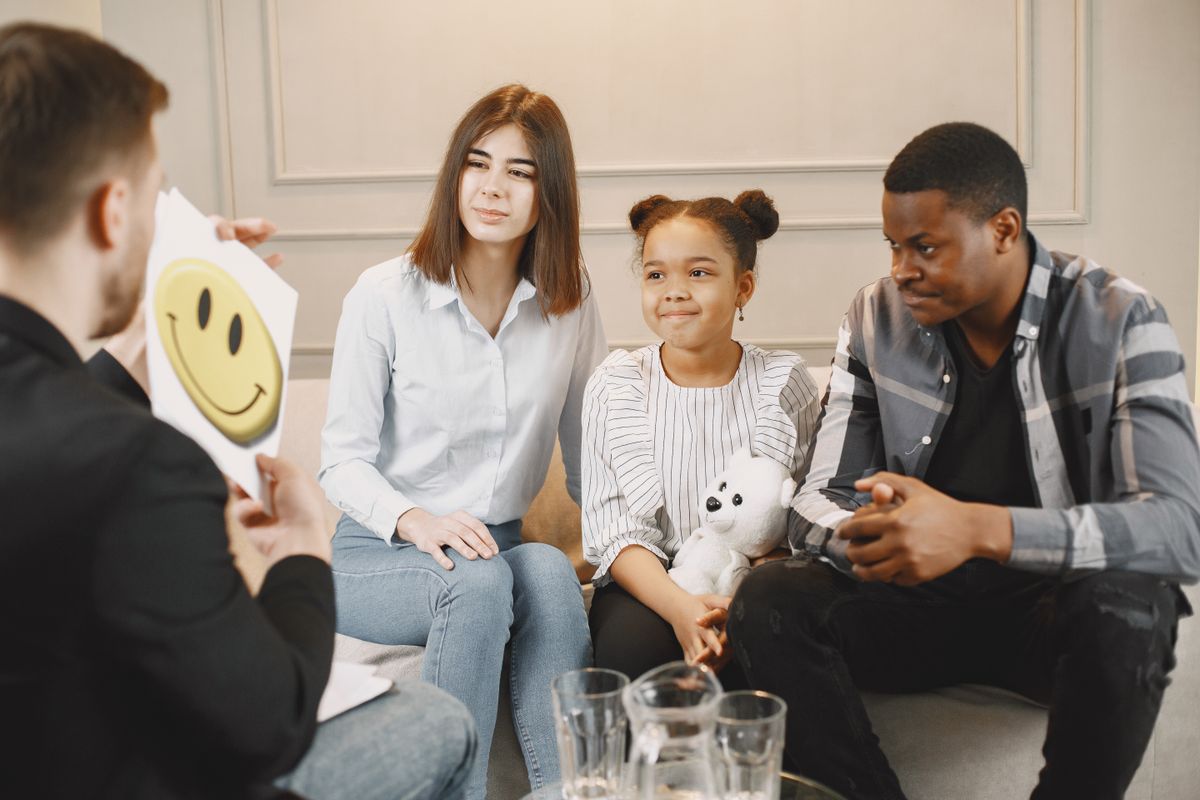Famille échangeant avec un professionnel pendant une séance de guidance parentale