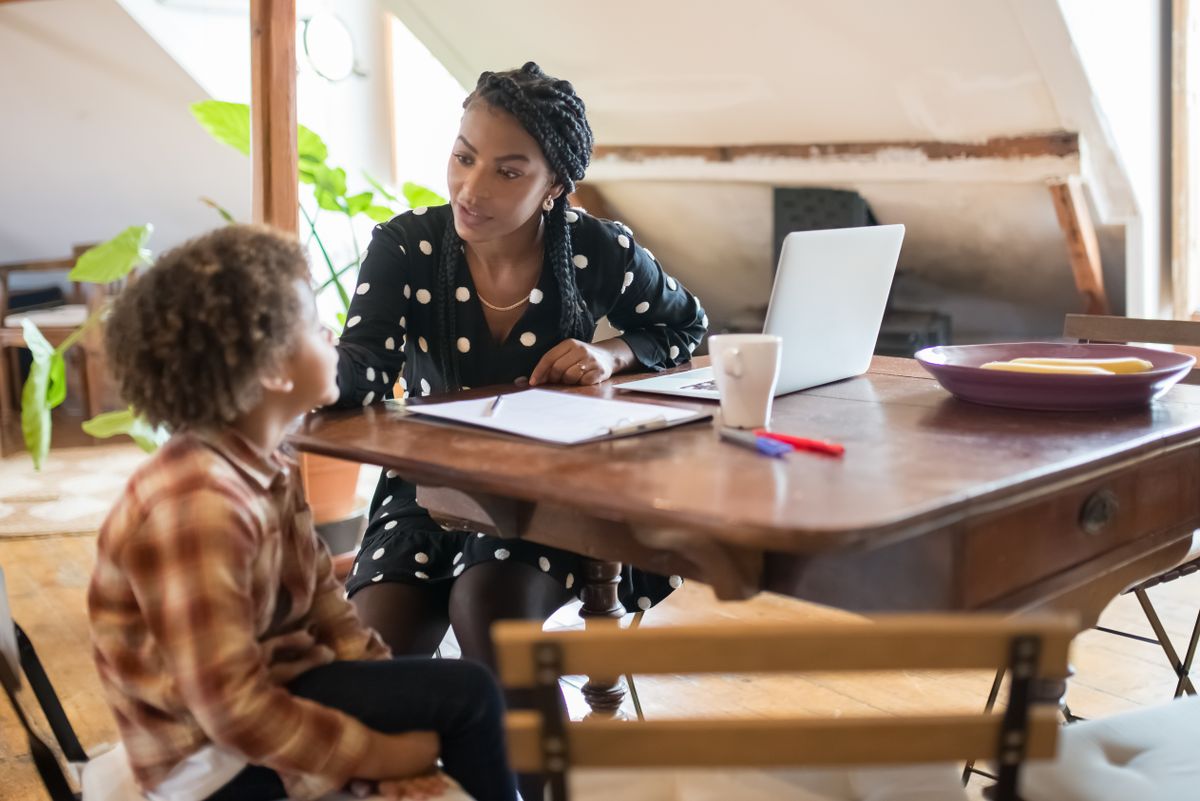 Parent parlant calmement avec son enfant autour d'une table