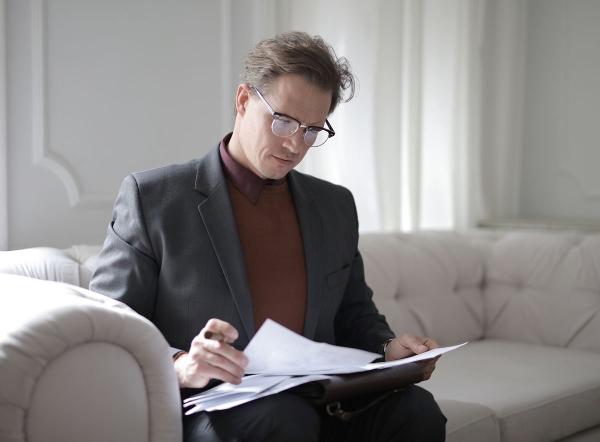 Professionnel relisant des documents dans un moment de doute